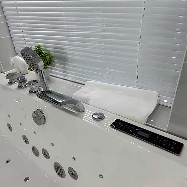 Close-up of brass faucet set with waterfall spout and handheld shower attachment