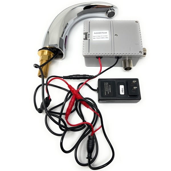 Automatic sensor faucet components arranged on a white surface, including chrome spout, control box, wiring, and power adapter.