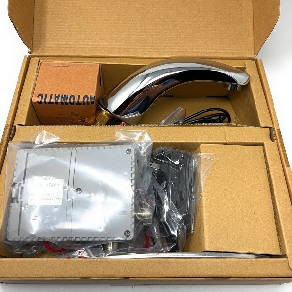 Boxed set containing a chrome sensor faucet spout, electronic control unit, and accessories in cardboard packaging.