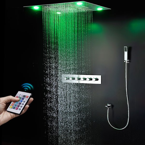 Modern rainfall shower with green LED lighting, a wall-mounted control panel, and a hand holding a color-changing remote.
