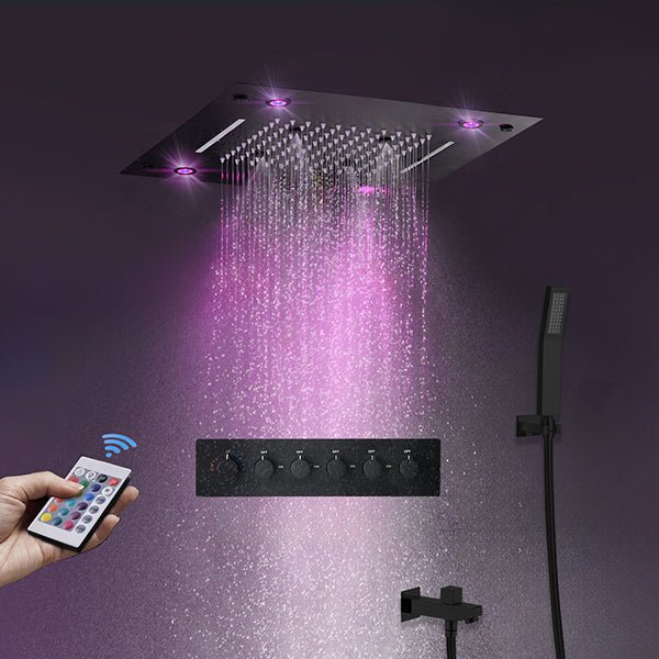 Black rainfall shower head with purple LED lighting and flowing water, with a hand holding a wireless remote.