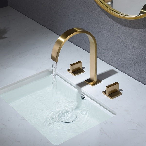 Water flowing from brushed gold waterfall spout